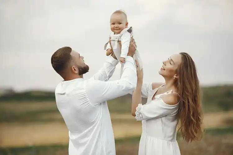 新移民家庭在户外抱起孩子，享受幸福新生活